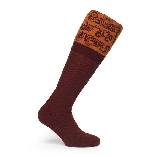 Image showcasing a country boot welly sock with intricate scroll details at the top, made from luxurious merino wool. Crafted in England and made to order by a sustainable company, epitomizing timeless style and eco-conscious craftsmanship