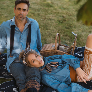 fashionable couple sitting on a personalised blanket having a picnic