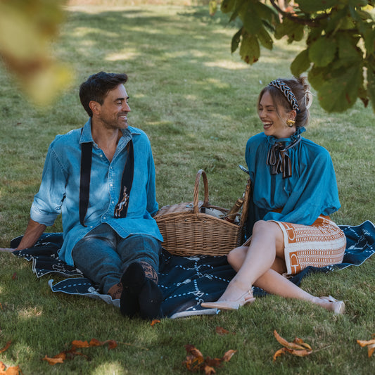 couple sat on blanket, man and woman stylish looking happy. Personalised gifts