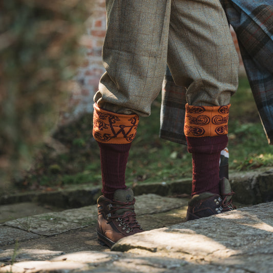 Image showcasing a country boot welly sock with intricate scroll details at the top, made from luxurious merino wool. Crafted in England and made to order by a sustainable company, epitomizing timeless style and eco-conscious craftsmanship